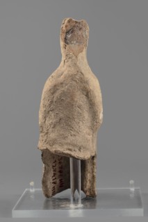 Female figurine, Female figure in a seated position, slightly leaning forward. The back of the