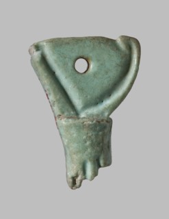 Amulet in the shape of a crown of Lower Egypt. Between the back of the crown and the rod, a plane