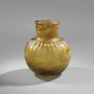 Bottle, household glass vessel, decorated with fluting on the shoulders that flow into a wide, low