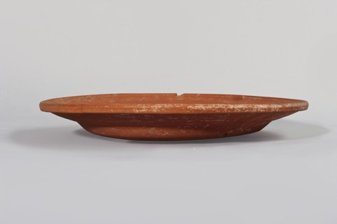 Terra sigillata plate. Flat plate with a very low foot and a rather flat, wide rim. Made of clay