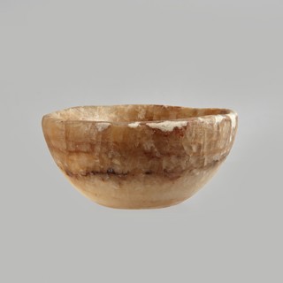 Bowl made of striped, coarse-crystalline Egyptian alabaster, waxed, with a flat bottom and gently