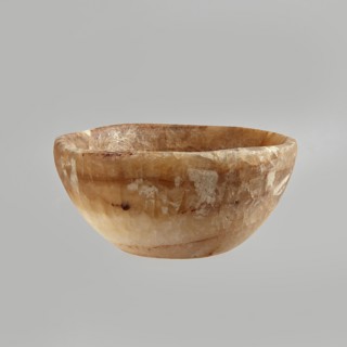 Bowl made of striped, coarse-crystalline Egyptian alabaster, waxed, with a flat bottom and gently
