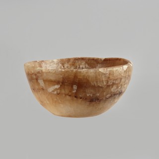 Bowl made of striped, coarse-crystalline Egyptian alabaster, waxed, with a flat bottom and gently