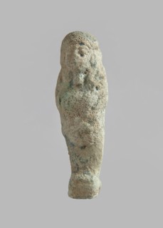 Ushabti, carelessly made figurine with schematic facial features, in a narrow wig revealing the