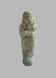 Ushabti. Carelessly made figurine with schematic facial features, in a narrow wig revealing the