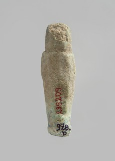 Ushabti. Carelessly made figurine with schematic facial features, in a narrow wig revealing the