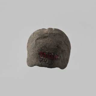 Head of a female figurine, preserved from the chin up. High hairstyle with a wreath above the