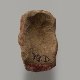 Fragment of a figurine - head of a man. Head of a male figurine. High forehead, above it fragments