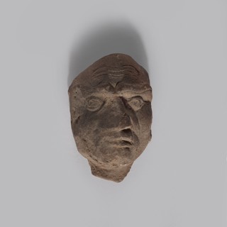 Head of a man. Fragment of a terracotta figurine showing the head of an elderly man. Thin face with