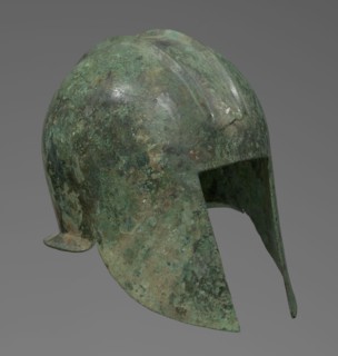 Bronze helmet with rectilinear cutouts for the eyes, nose, mouth, and chin. The helmet has two