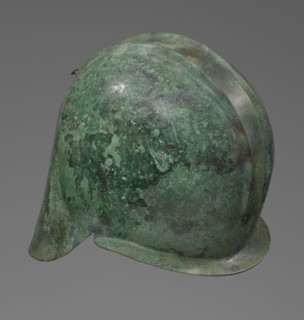 Bronze helmet with rectilinear cutouts for the eyes, nose, mouth, and chin; the helmet has two