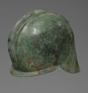 Bronze helmet with rectilinear cutouts for the eyes, nose, mouth, and chin; two prominent