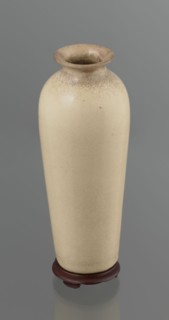 Cylindrical porcelain vase, tapering towards the bottom; flat rim. Light cream glaze with fine