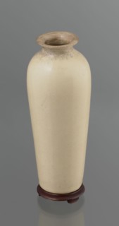 Cylindrical porcelain vase, tapering towards the bottom; flat rim. Light cream glaze with fine