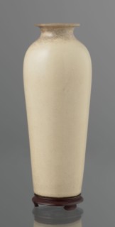 Vase on saucer. Cylindrical porcelain vase tapering toward the bottom with a flat rim. Light cream