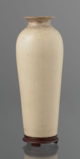 Cylindrical porcelain vase, tapering towards the bottom; flat rim. Light cream glaze with fine