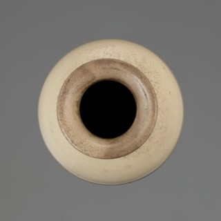 Cylindrical porcelain vase tapering toward the bottom with a flat rim; light cream glaze with fine