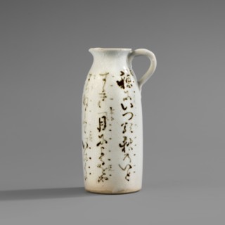 Cylinder-shaped jug with small handle and widened spout. White glaze with fine crackle; decoration