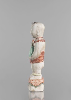 One of the Hehe Er Xian brothers holding a vase with lotus buds; maker, Chinese porcelain