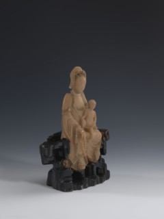 Guanyin Giving Birth to a Son on a Rock; sculptor unknown. Figurine of the goddess Guanyin holding
