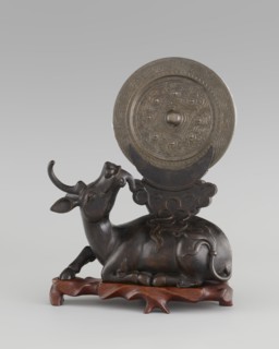 Mirror with TLV decoration on a pedestal in the form of a qilin on a base. Chinese; Qing dynasty