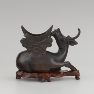 Mirror with TLV decoration on a pedestal in the form of a qilin on a base. Chinese; Qing dynasty