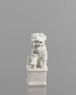 Foo lion figurine with a ball;, lion iconography; ceramics; blanc de Chine porcelain; figurine;