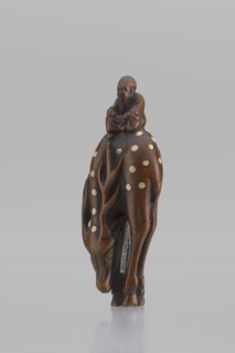 Netsuke in the shape of Fukurokuju riding a deer. The deer has all its legs put together so that