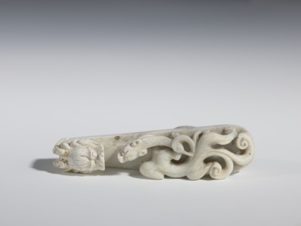 Belt clasp. Handle: stylized lizard-dragon qilong. Milky-white jadeite. Full-plastic carved head,