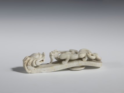 Belt clasp. Handle: stylized lizard-dragon qilong. Milky-white jadeite. Full-plastic carved head,