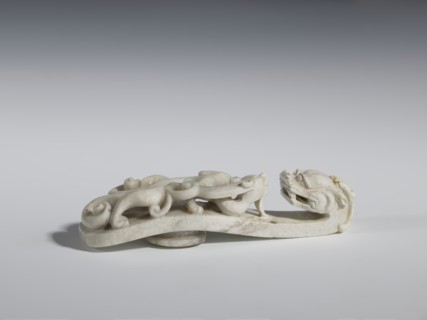 Belt clasp. Handle: stylized lizard-dragon qilong. Milky-white jadeite. Full-plastic carved head;