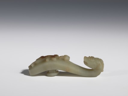 Belt clasp. Handle flattened on the sides, decorated with a lizard-dragon motif. Jadeite with
