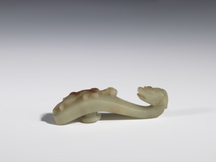 Belt clasp. Handle flattened on the sides, decorated with a lizard-dragon motif. Jadeite with
