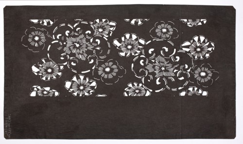 A katagami dyeing stencil cut into a pattern of stylized flower rosettes of various sizes