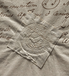 Round seal impression of the town of Losice. Under the crown in a rim of palm branches, a female