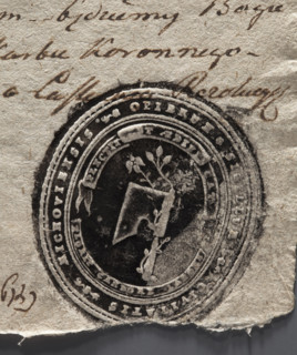 Oval print of the seal of the town of Miechów. Axe with a rose branch entwined around the axe