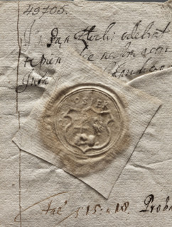 Round seal impression of the town of Osiek. On a decorative shield divided into a column: in the