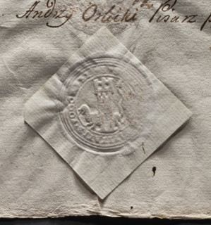 Round imprint of the city seal of Pogorzela. Tower with a gate and three battlements; behind it a