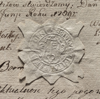 Round imprint of the seal of the town of Stopnica. In a decorative cartouche a key - tooth up.