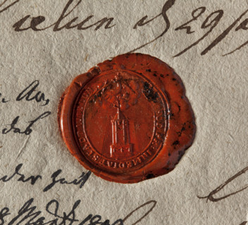 Oval wax seal of the city of Wielun. Obelisk on a pedestal decorated with garlands; a banner atop.