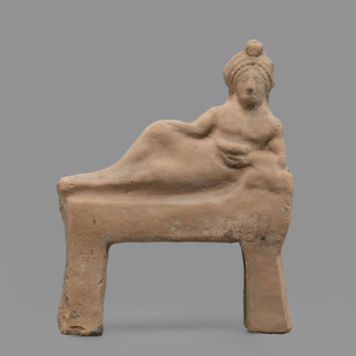 Figurine of a feasting Dionysus — figurine of a feasting man resting on a bed in a semi-reclining