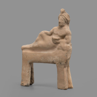 Figurine of a feasting Dionysus: figurine of a feasting man resting on a bed in a semi-reclining