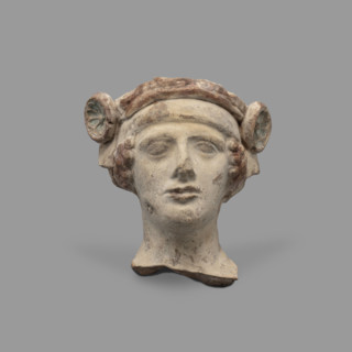 Head of a figurine of Dionysus. Head of a young man with a face devoid of [expression?], wide