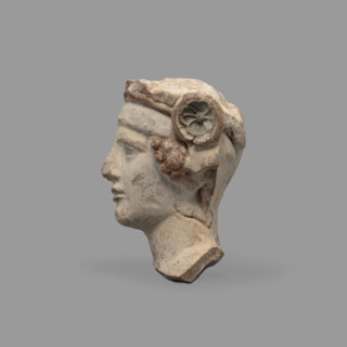 Head of a figurine of Dionysus. Head of a young man with a face devoid of [expression], wide