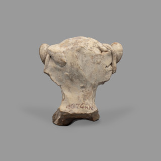 Head of a figurine of Dionysus. Head of a young man with a face devoid of expression, with a wide,