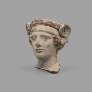Head of a figurine of Dionysus. Head of a young man with a face devoid of [expression?], with a