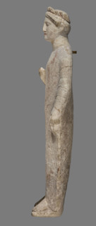 Votive figure of a youth holding a bird, Cypriot votive sculpture. Figurine of a youth shown