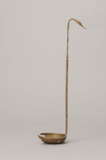 Shallow dipper with a quadrilateral handle, narrowed at the top. The end of the handle is in the