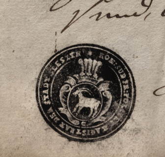 Round ink print of the seal of the town of Sleszyn. In a baroque cartouche, under an open crown
