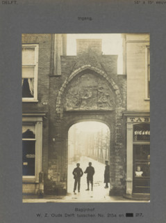 Entrance gate to the Bagijnhof in Delft with three people, Bagijnhof. WZ Oude Delft between No.